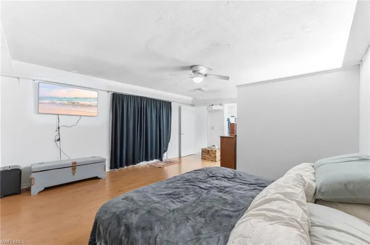 Main bedroom with light wood-style flooring, a ceiling fan, and a textured ceiling