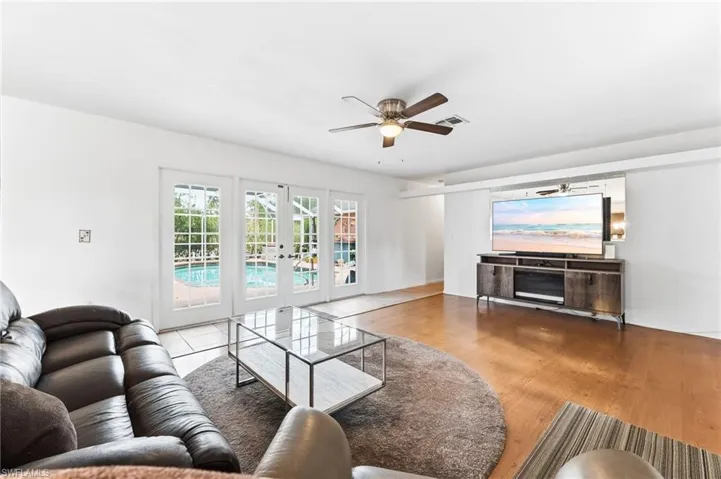 Living room with ceiling fan, french doors, and wood finished floors