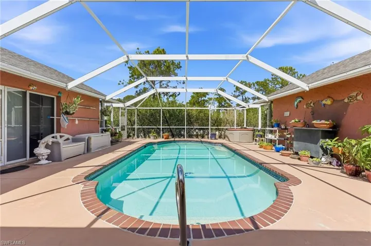Outdoor pool featuring a lanai, a sunroom, and a patio area