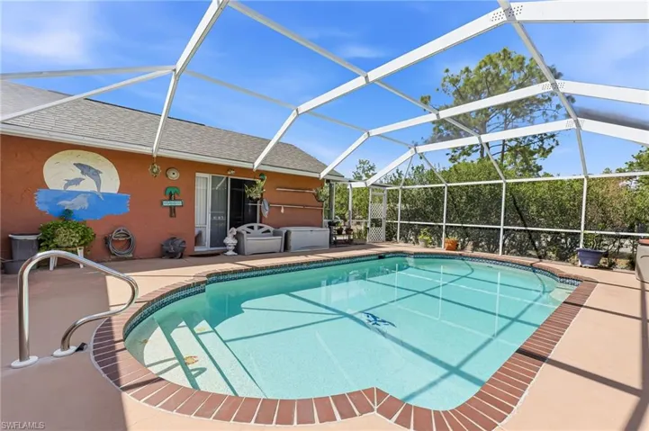 Swimming pool featuring glass enclosure, a sunroom, and a patio