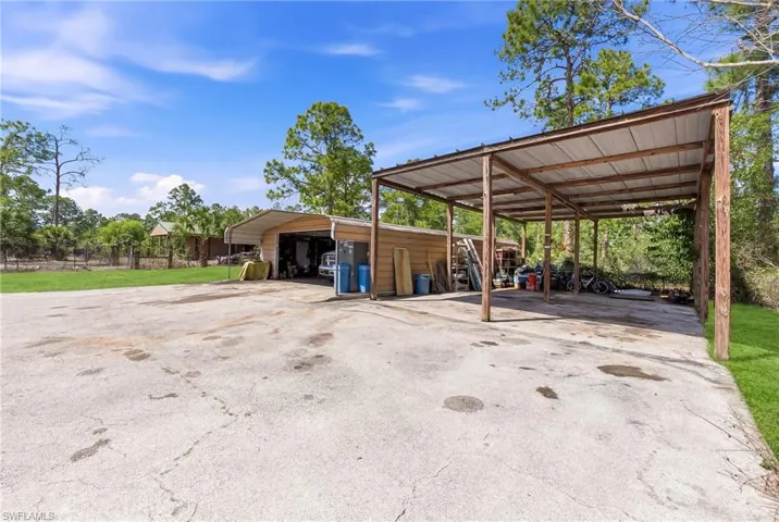View of parking with a detached garage and driveway