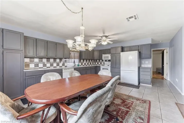 Dining space featuring hanging lights and light tile patterned flooring