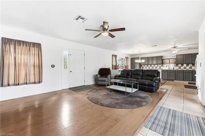 Living room featuring ceiling fan, hanging lights, and light tile patterned flooring