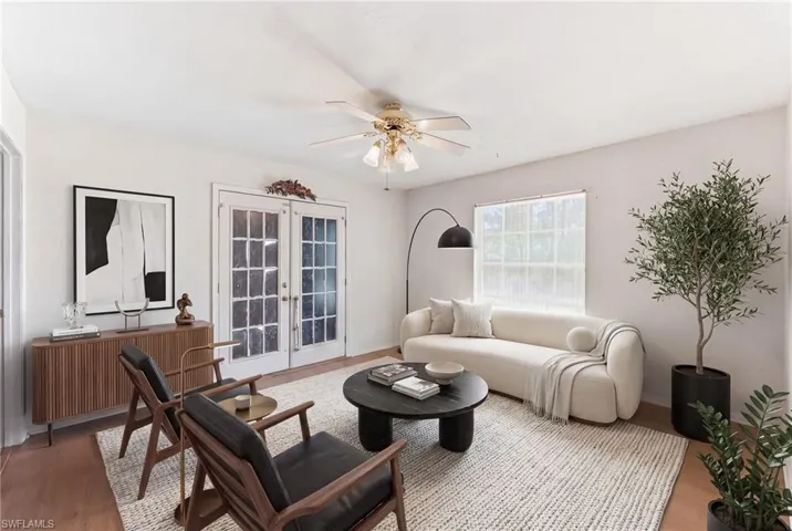 Virtually staged den with french doors, ceiling fan, and light wood finished floors