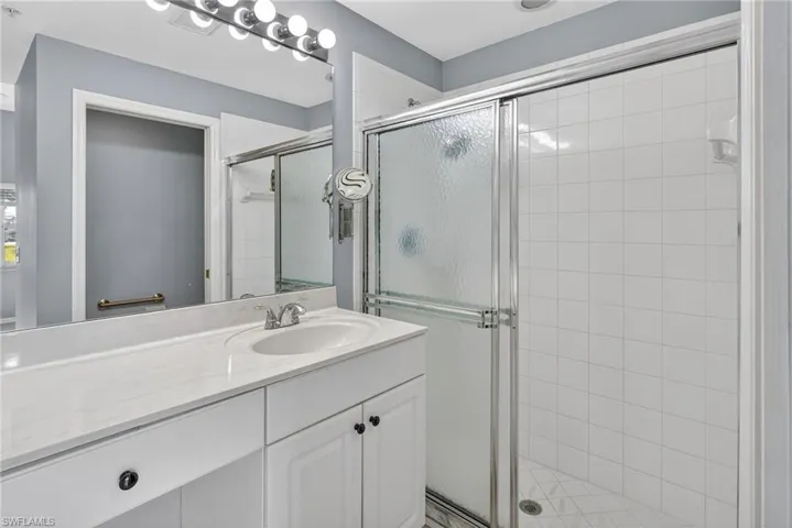 Bathroom featuring a single vanity with an undermount sink and a light-colored countertop