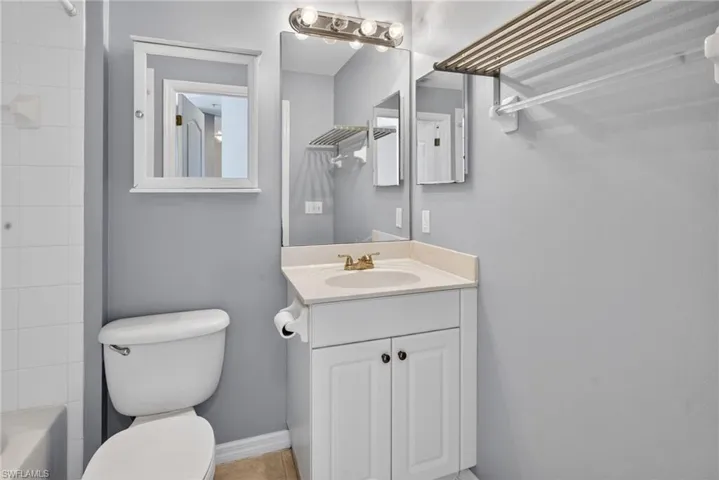 Full bathroom featuring a white vanity with integrated sink, coordinating wall mirror with integrated lighting, and a medicine cabinet