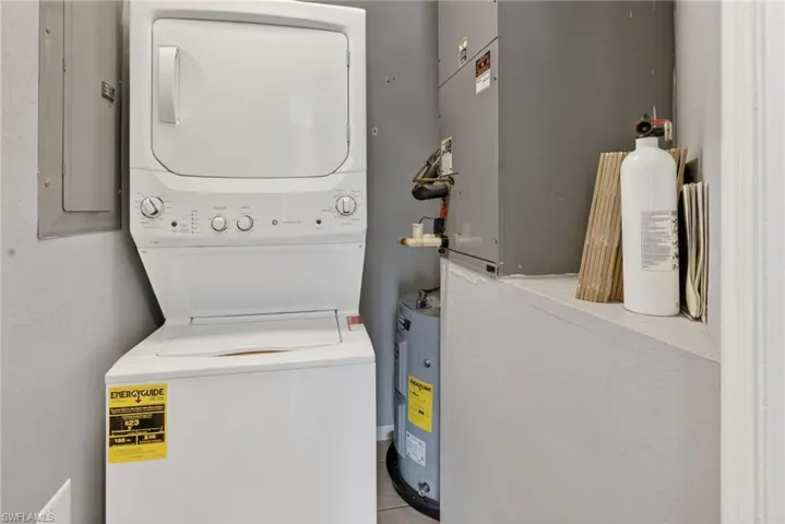In-Unit Stackable white laundry appliances with a water heater and HVAC unit
