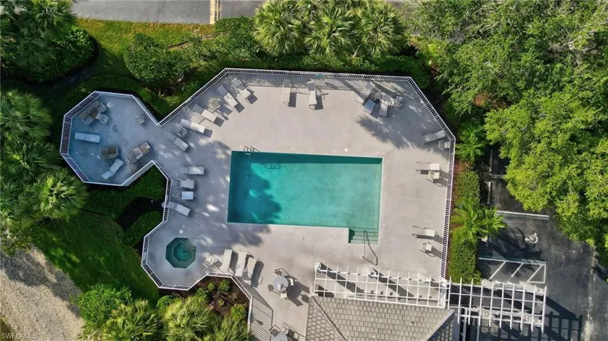 Expansive pool deck featuring a rectangular swimming pool, integrated spa, and multiple lounge areas