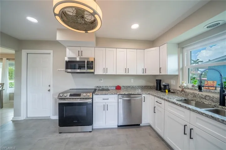 Kitchen featuring stainless steel appliances, white cabinetry, healthy amount of natural light, and recessed lighting