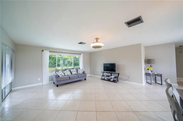 Living area featuring light tile patterned flooring and baseboards