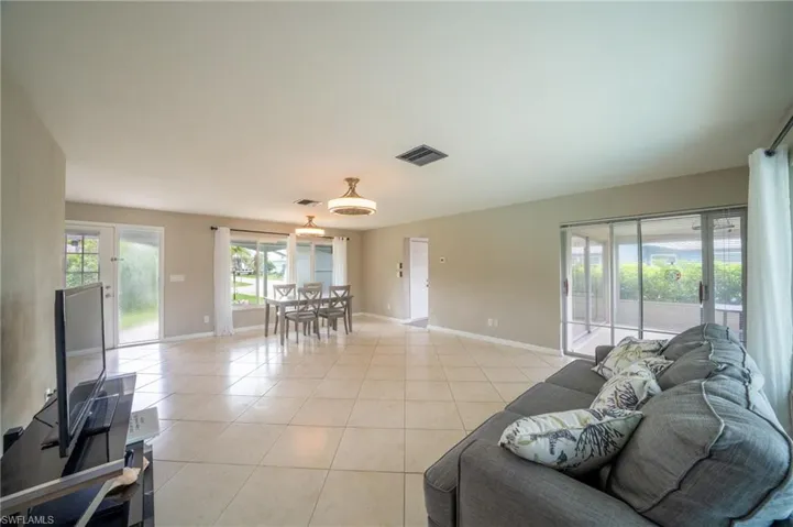 Living room with light tile patterned flooring and baseboards