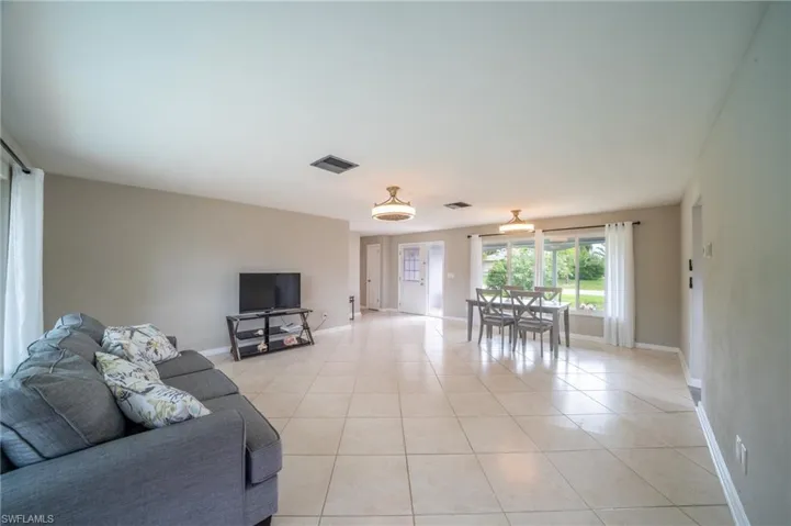 Living area with light tile patterned flooring and baseboards
