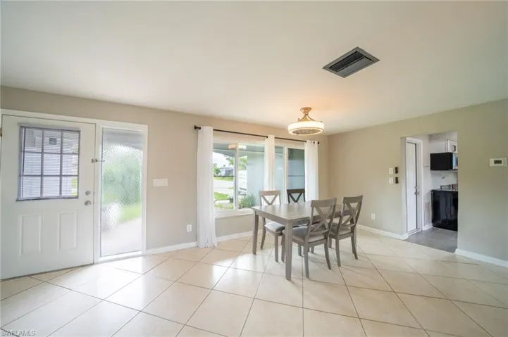 Dining area with light tile patterned floors and baseboards
