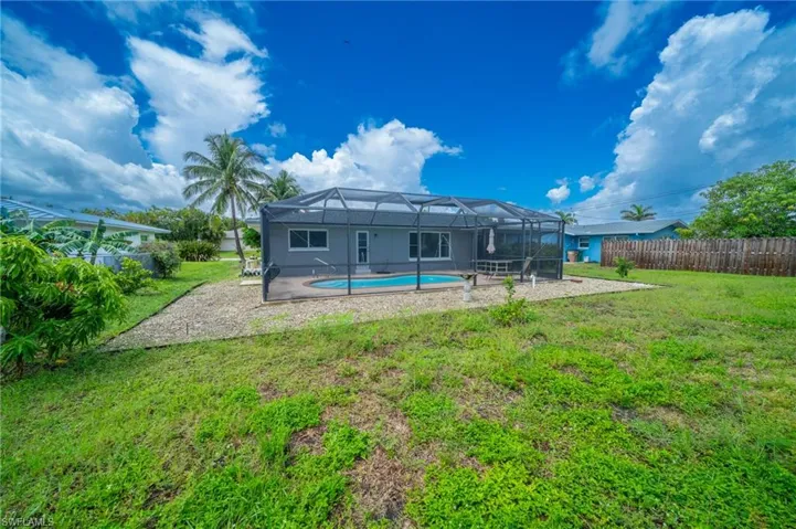 Rear view of house with glass enclosure and a patio area