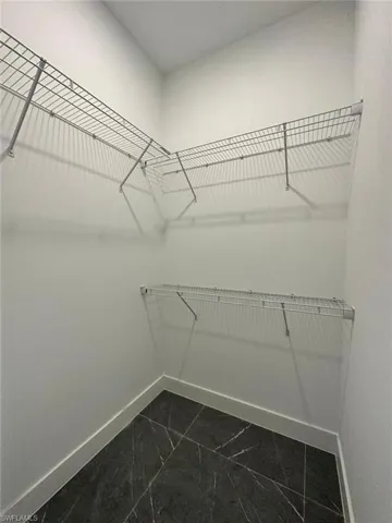 Spacious closet featuring marble finish floor