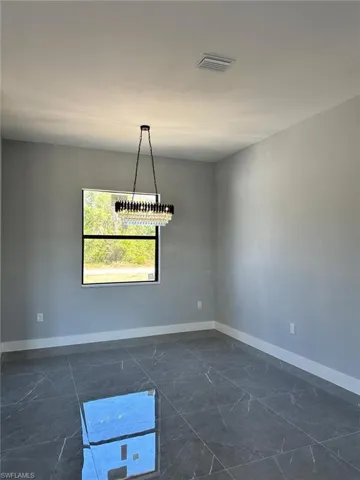 Unfurnished room featuring marble finish floor, baseboards, and visible vents