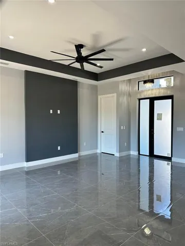 Spare room with marble finish floor, baseboards, recessed lighting, and ceiling fan with notable chandelier