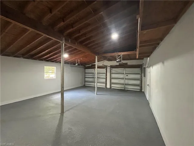 Garage featuring baseboards and a garage door opener