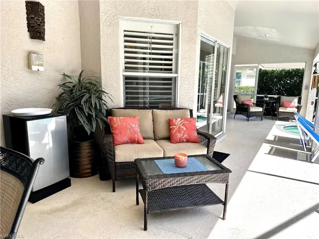 Just outside the kitchen and living room is a sofa, cocktail table, and beverage fridge for outdoor relaxing and entertaining.