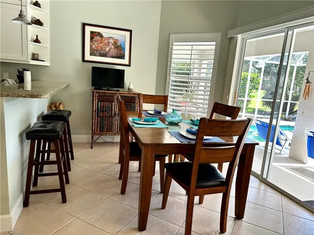 Kitchen includes a breakfast bar an room for a full size dining table.