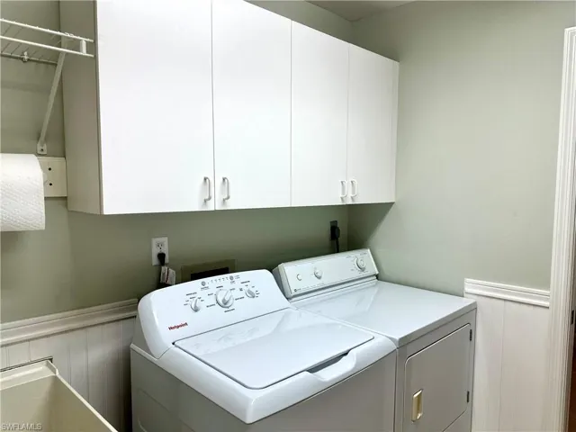 The laundry room includes storage cabinets and a laundry sink.