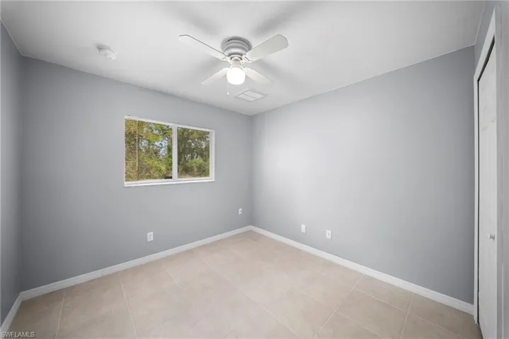 Empty room with baseboards and a ceiling fan