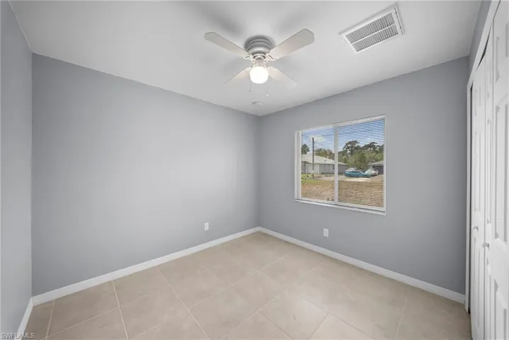 Unfurnished room featuring a ceiling fan and light tile patterned flooring