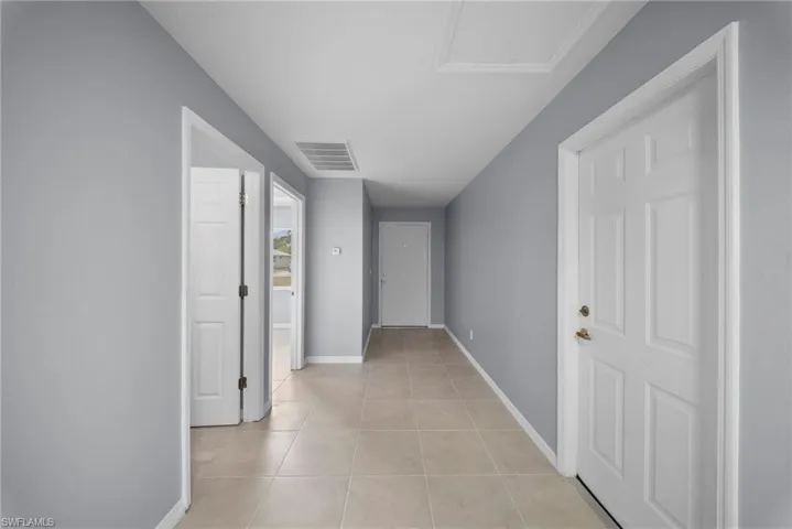 Corridor with baseboards and light tile patterned flooring