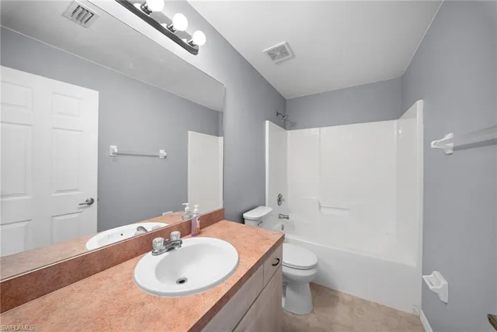 Full bathroom with vanity, bathtub / shower combination, and light tile patterned flooring