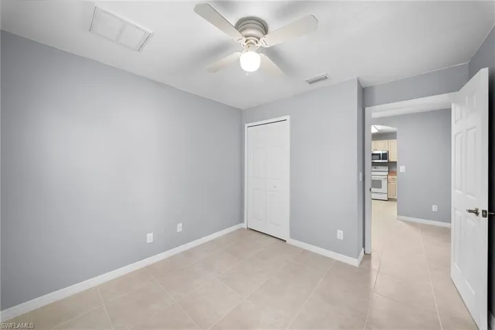 Unfurnished bedroom with a ceiling fan, a closet, and light tile patterned floors