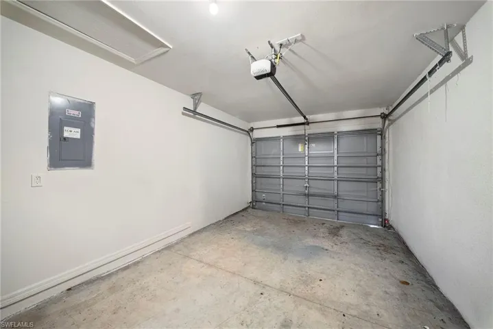 Garage featuring electric panel and a garage door opener
