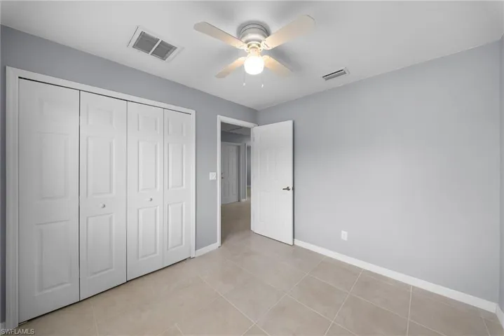 Unfurnished bedroom featuring ceiling fan, a closet, and light tile patterned flooring
