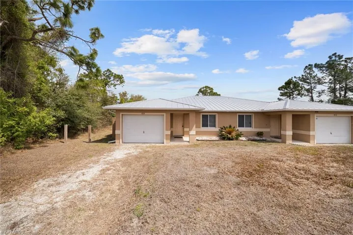 Ranch-style home featuring an attached garage, stucco siding, and driveway
