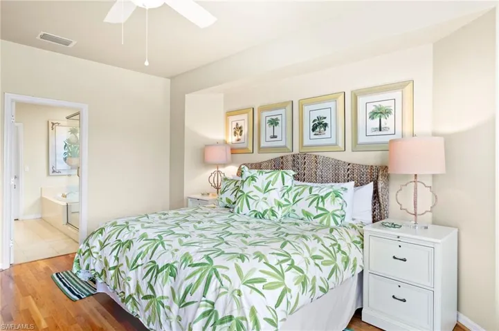 Bedroom with wood finished floors and connected bathroom