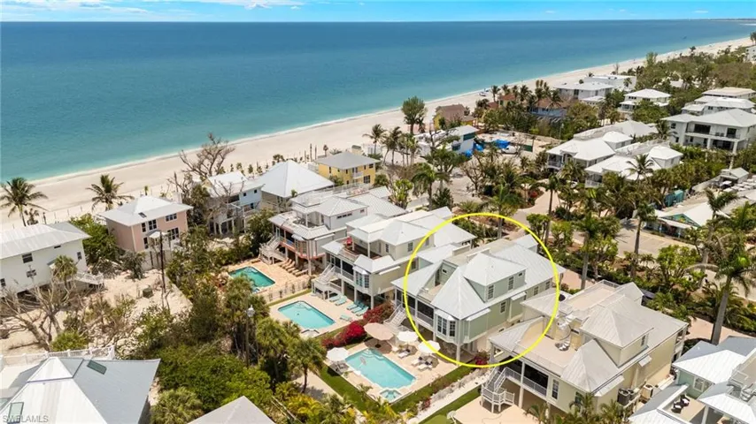Aerial perspective of suburban area with a pool and expansive coastline