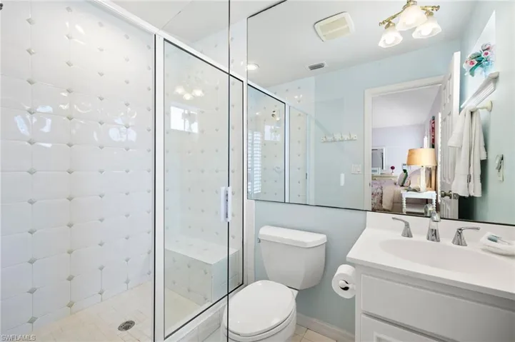 Ensuite bathroom with vanity, a stall shower, and toilet