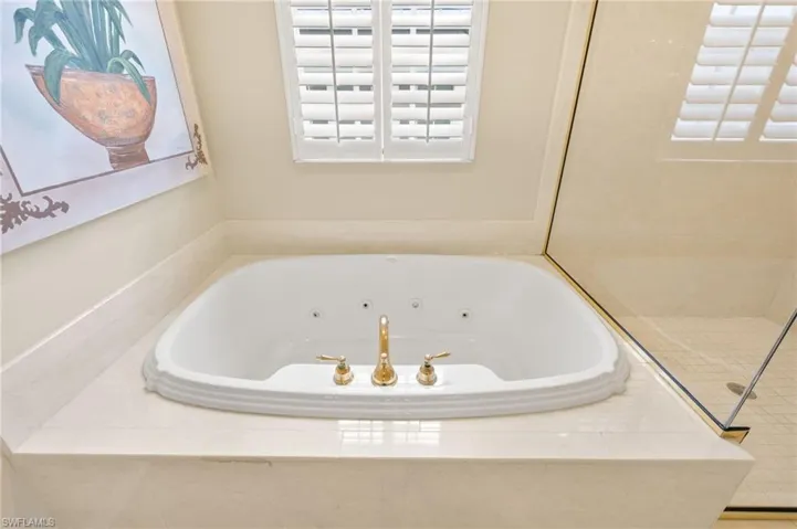 Full bathroom featuring a jetted tub and a tile shower