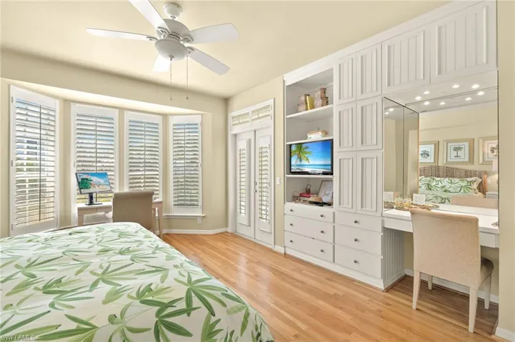 Bedroom with light wood finished floors, baseboards, and ceiling fan