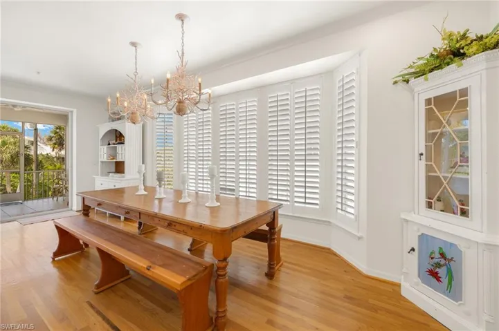 Dining space with a chandelier, light wood-style floors, and baseboards