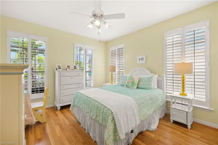 Bedroom featuring light wood-type flooring, baseboards, and ceiling fan