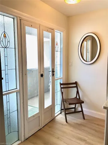 Doorway with wood finished floors and french doors