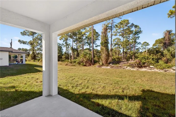 View of green lawn with a patio area