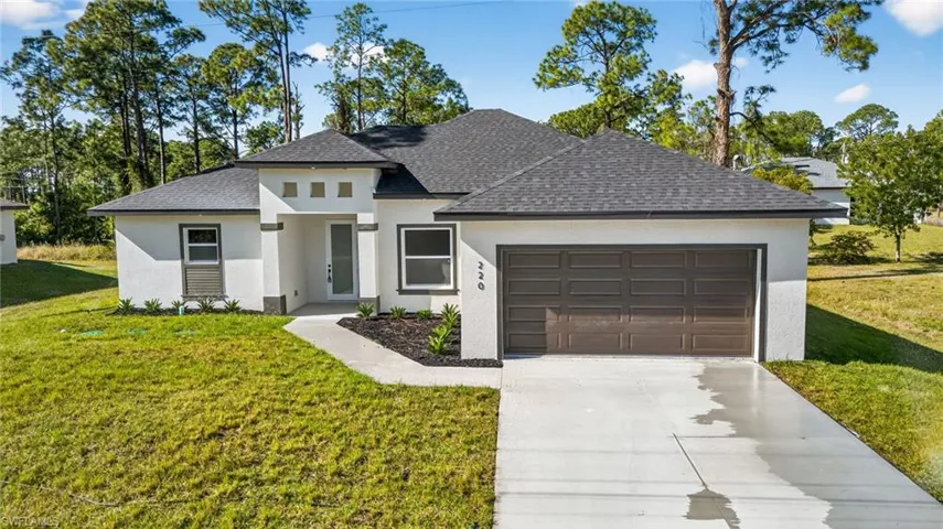 View of front of house featuring a front lawn, roof with shingles, driveway, stucco siding, and an attached garage