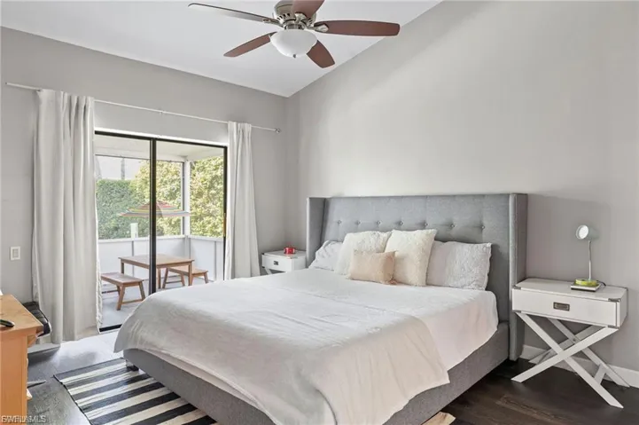 Bedroom featuring access to outside, ceiling fan, dark wood-style floors, and lofted ceiling