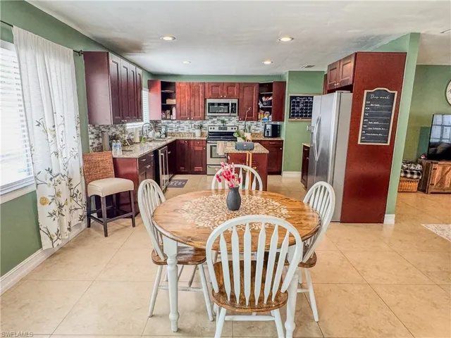 Dining space featuring plenty of natural light, light tile patterned flooring, recessed lighting, and baseboards