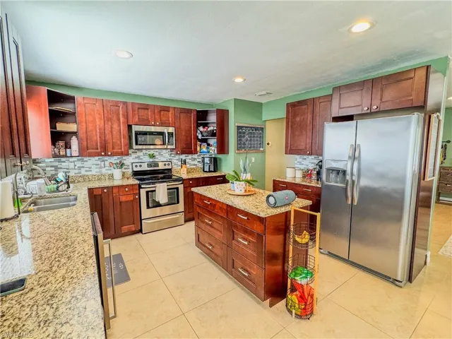 Kitchen with open shelves, appliances with stainless steel finishes, decorative backsplash, a sink, and recessed lighting