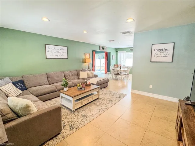Living room featuring light tile patterned floors, baseboards, and recessed lighting