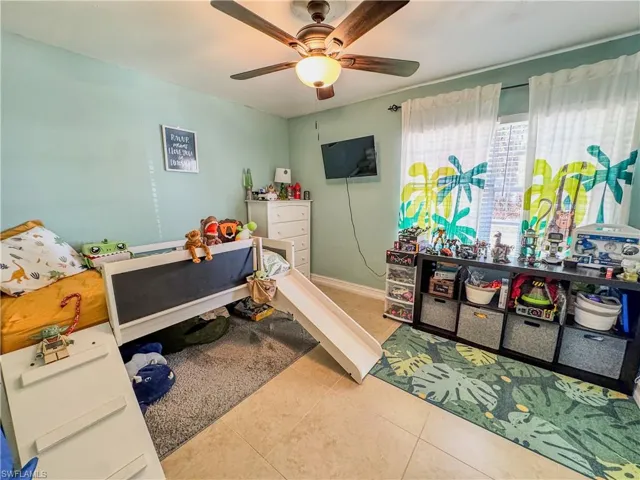 Tiled bedroom with a ceiling fan
