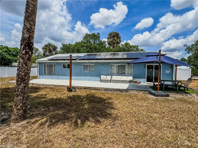 Rear view of property featuring a patio area, stucco siding, and roof mounted solar panels