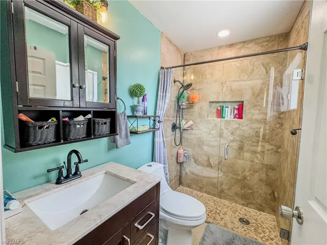 Bathroom with a stall shower, toilet, and vanity